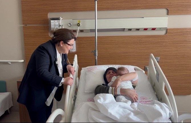 Earthquake survivor mother Yasemin Begdas reunites with her baby girl Vetin as Derya Yanik, minister of family and social services, looks on at a hospital in Adana, Turkiye. (Reuters)