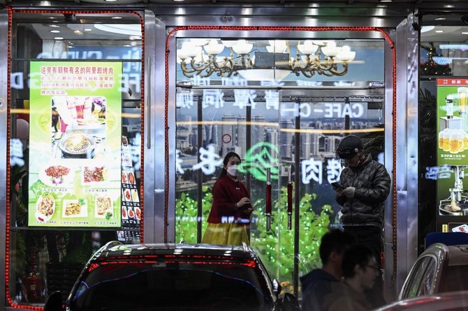 Above, a North Korean worker, left, stands at the entrance of a North Korean restaurant in Shenyang of China’s northeastern Liaoning province on March 31, 2023. (AFP)