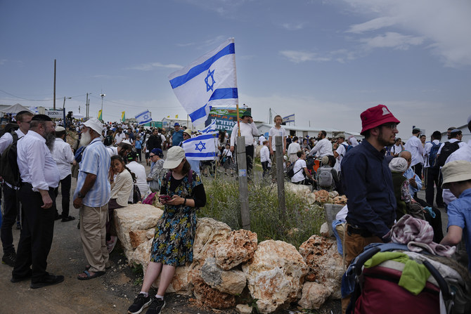 Israeli settlers walk around the outpost of Eviatar in the West Bank, Monday, April 10, 2023. (AP)