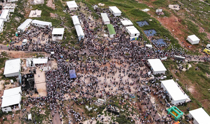 Israeli settlers gather at the Israeli settler outpost of Avitar, as part of a protest march from Tapuach Junction to Avitar in the Israeli-occupied West Bank, April 10, 2023. (Reuters)