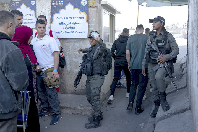 Israeli border police officers check identification cards of Palestinians while they try to cross from the occupied West Bank into Jerusalem to pray during the holiest night of Ramadan on April 17, 2023. (AP)