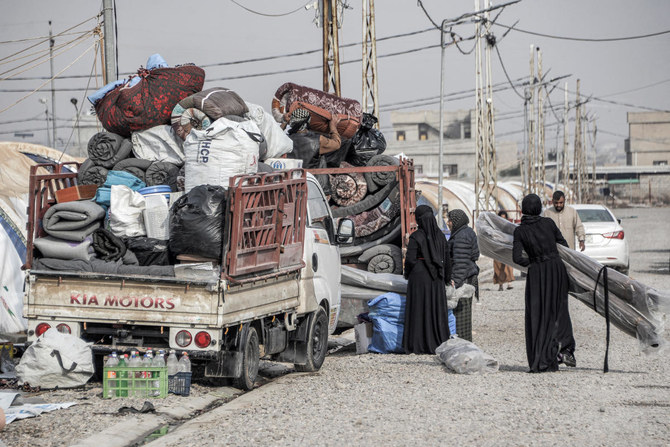 Members of an Iraqi family pack their belongings in the back of a pickup truck as they prepare to return home and move out of the Jadaa camp for the displaced, south of Iraq's northern city of Mosul on December 21, 2022. (AFP)
