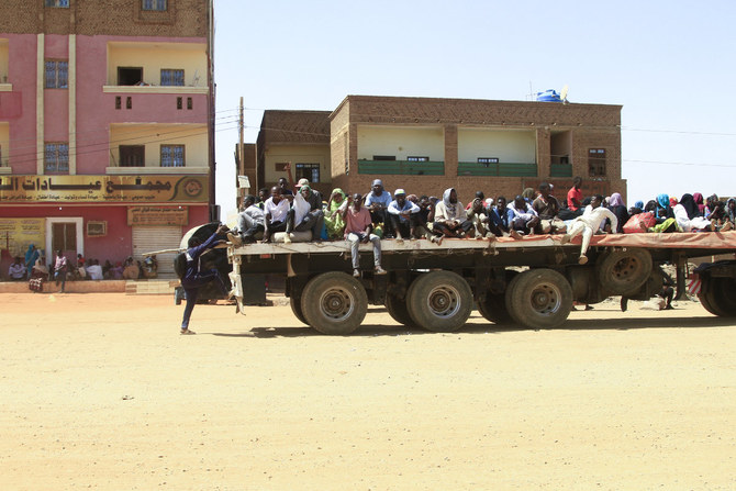 People fleeing street battles between the forces of two rival Sudanese generals are transported on the back of a truck in the southern part of Khartoum, on April 21, 2023. (AFP)