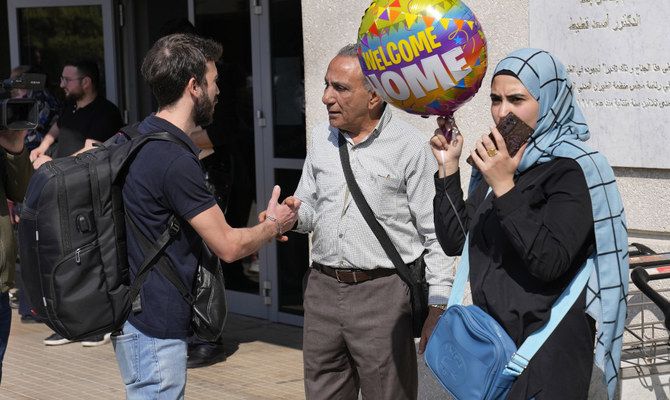 Lebanese citizens who evacuated from Sudan, shake hands as they welcomed by their families upon their arrival at Rafik Hariri international airport, in Beirut, Lebanon, Tuesday, April 25, 2023. (AP)