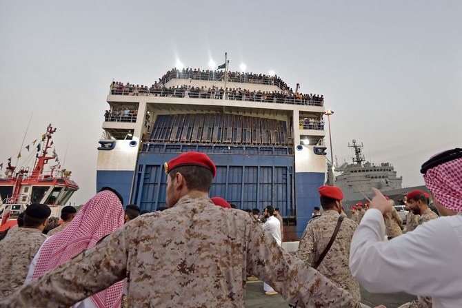 Members of the Saudi Navy Forces assist evacuees arriving at King Faisal navy base in Jeddah on April 26, 2023. (AFP)