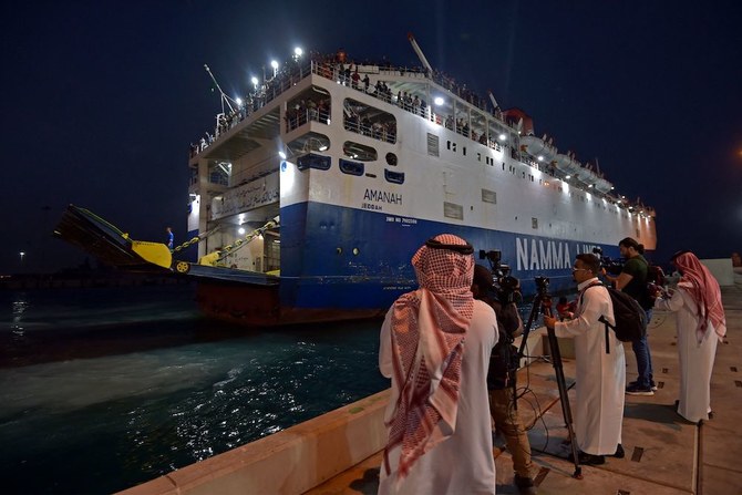 Members of the Saudi Navy Forces assist evacuees arriving at King Faisal navy base in Jeddah on April 26, 2023. (AFP)