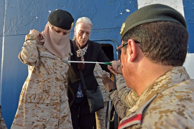 Members of the Saudi Navy Forces assist evacuees arriving at King Faisal navy base in Jeddah on April 26, 2023. (AFP)