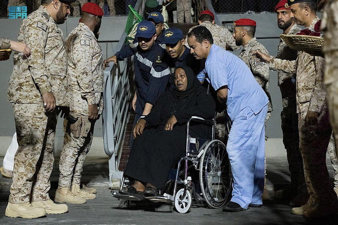 Saudi Navy personnel at the Jeddah Sea Port assist civilians of different nationalities who were evacuated from Sudan on April 27, 2023, to escape the raging war. (Saudi Press Agency/Handout via REUTERS)
