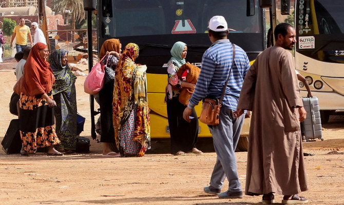 Sudanese and people from other nationalities evacuated from Khartoum wait to board a bus. (Reuters)