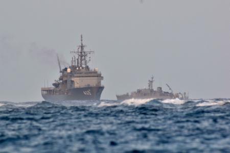 Japan Maritime Self-Defense Force vessels, including the submarine rescue ship Chihaya (left), search the waters off Miyakojima, Okinawa prefecture, where an object believed to be the missing Ground Self-Defense Force UH-60JA helicopter was confirmed, on April 16, 2023. (Photo by JIJI PRESS / AFP)