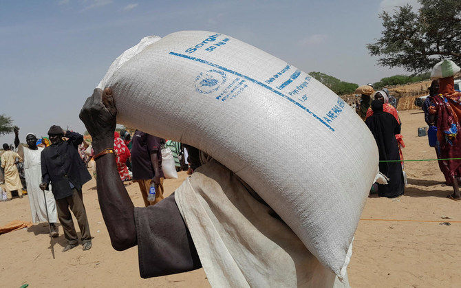 A worker of World Food Programme (WFP) carries a bag of relief grains to be distributed to Sudanese refugees who have fled the violence in their country, near the border between Sudan and Chad, in Koufroun, Chad April 28, 2023. (Reuters)