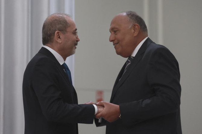 Jordanian Foreign Minister Ayman Safadi, left, shakes hands with his Egyptian counterpart Sameh Shoukry during a regional consultative meeting held in Amman, Jordan on Monday, May 1, 2023. (AP)