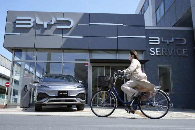 Osamu Furukawa stands next to his new BYD ATTO 3 electric car in Yokohama, south of Tokyo, on April 25, 2023. (AP)