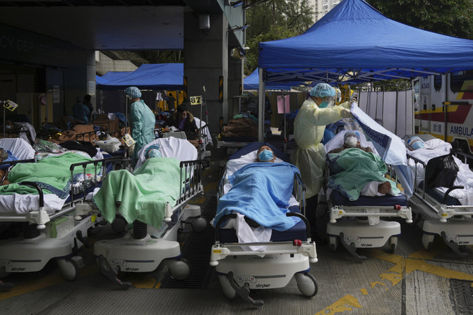 Patients lie on hospital beds as they wait at a temporary makeshift treatment area outside Caritas Medical Centre in Hong Kong on Feb. 18, 2022. (AP File Photo)
