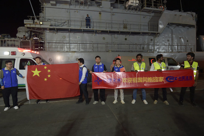 Chinese citizens evacuated from Sudan display their country's banners as they arrive at King Faisal navy base in Jeddah on April 26, 2023. (AFP)