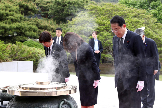 Japanese Prime Minister Fumio Kishida and his wife Yuko pay a silent tribute during a visit to National Cemetery in Seoul, South Korea. (REUTERS)