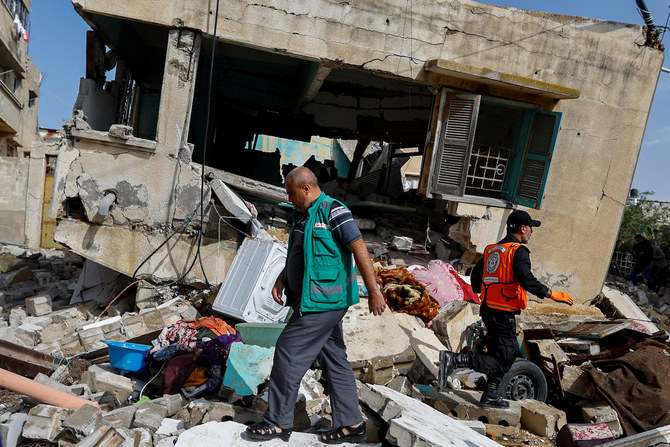 Palestinian rescue workers walk amid rubble after Islamic Jihad commander Ahmed Abu Daqqa was killed in an Israeli strike, in the southern Gaza Strip May 11, 2023. (Reuters)