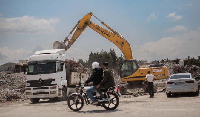 A excavator loads rubble onto a truck on a street in Antakya, on May 13, 2023, ahead of presidential and legislative elections on May 14, that could end President Recep Tayyip Erdogan's 21-year rule. (AFP)