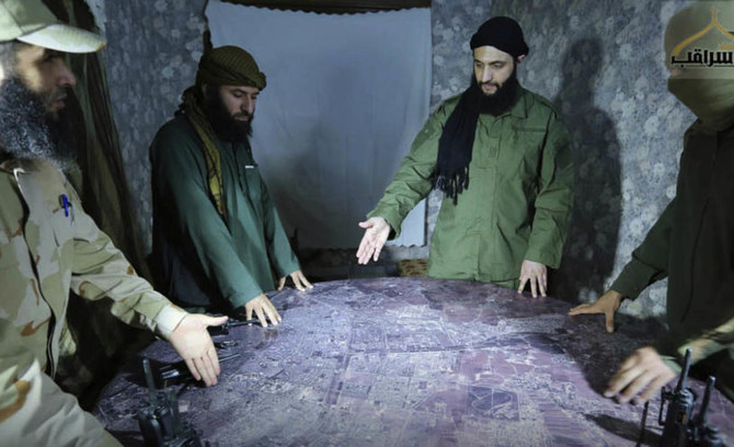 Abu Mohammed al-Golani, of the Levant Liberation Committee and the leader of Syria's al-Qaida affiliate, second from right, discusses battlefield details with field commanders over a map, in Aleppo, Syria. (File/AP)