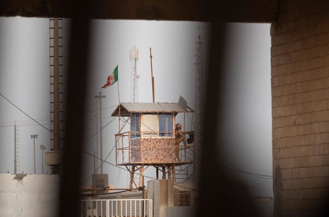 An Iranian border guard monitors from an observation post on the Iranian side of the border with Iraq the Shalamjah (Shalamcheh) crossing, near the southern Iraqi city of Basra, on August 31, 2022.(AFP)