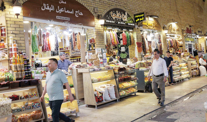 People walk past shops at a market in Irbil, northern Iraq. Turkey’s presidential election is being anxiously watched by Kurds in Syria and Iraq. (AFP)