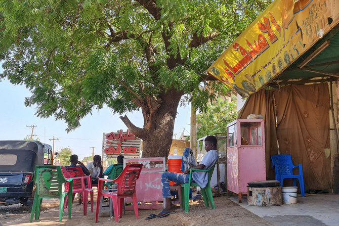 People rest under a tree in a roadside coffee shop in southern Khartoum on May 21, 2023, amid ongoing fighting between two rival generals. (AFP)