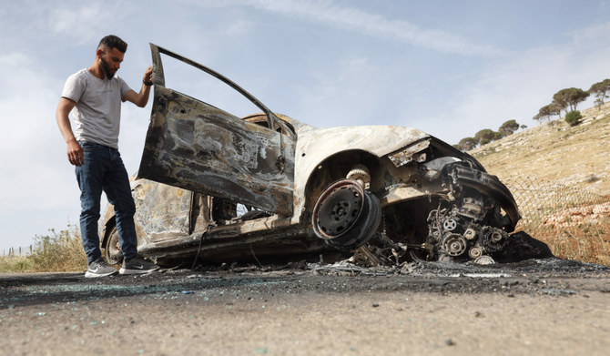 A Palestinian man inspects a car, reportedly burnt by Israeli settlers, in the village of Al-Mughayer, east of the occupied West Bank city of Ramallah on May 26, 2023. (AFP)