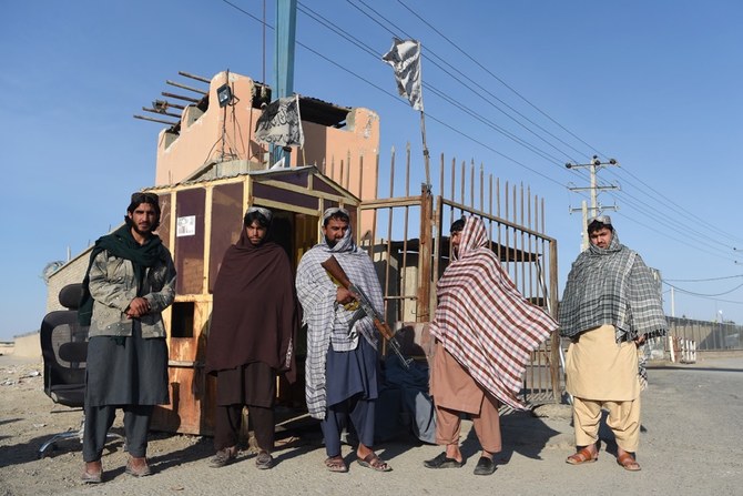 Taliban fighters stand guard at the entrance gate of Afghan-Iran border crossing bridge in Zaranj. (AFP)