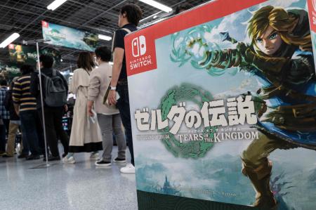 People queue up at the check-out counter as dozens of shoppers arrived early at a popular electronics chain store for the latest offering from Japanese gaming giant Nintendo's long-running 