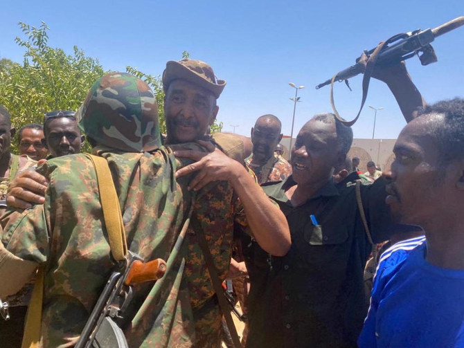 Sudan’s military leader General Abdel Fattah Al-Burhan, center, embraces soldiers in Khartoum in this handout image released May 17, 2023 by the Sudanese Military Media. (Sudanese Military Media via Reuters)