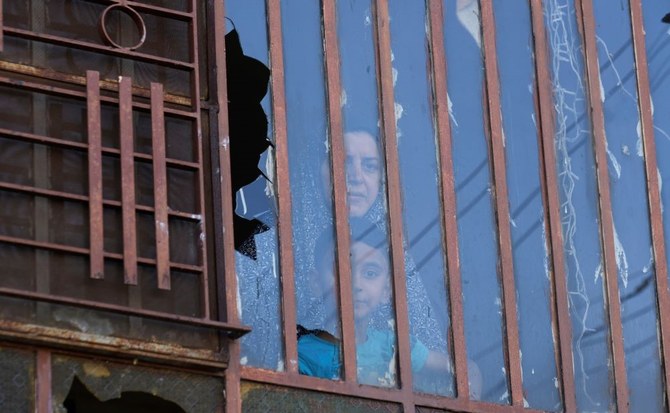 Palestinians look through a broken window, damaged by Israeli settlers, in the West Bank village of A Laban Al-Sharkiyeh, June 21, 2023. (AP Photo)