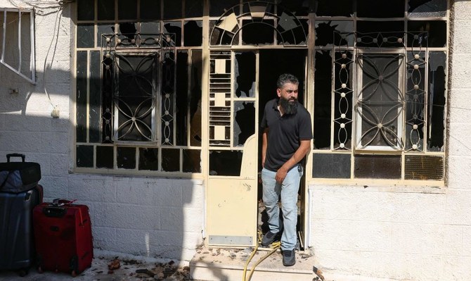 A Palestinian man prepares to leave his home, taking a few suitcases with him, after it was set on fire by Israeli settlers in Turmus Aya, occupied West Bank, June 21, 2023. (AFP)