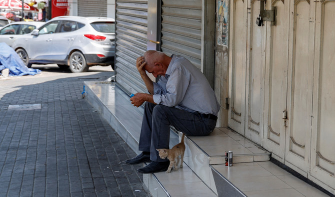A man sits outside a closed shop during a general strike following the killing of three Palestinian gunmen by an Israeli drone strike on Wednesday, in Jenin, in the Israeli-occupied West Bank, June 22, 2023. (Reuters)