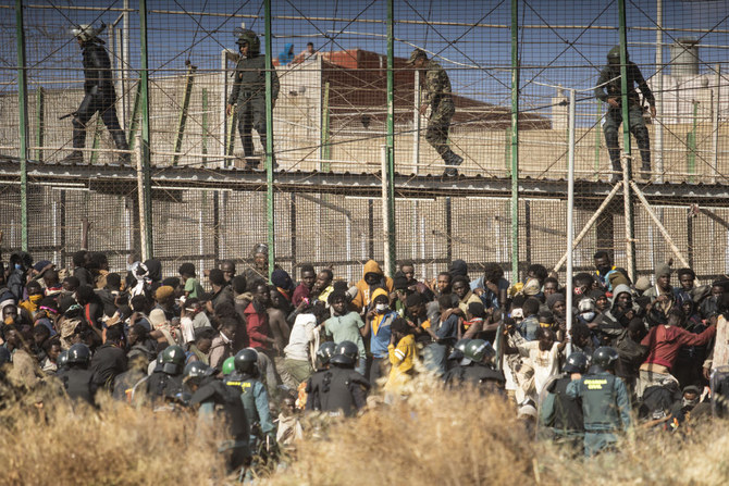 Riot police officers cordon off the area after migrants arrive on Spanish soil and crossing the fences separating the Spanish enclave of Melilla from Morocco in Melilla on June 24, 2022. (AP/File)