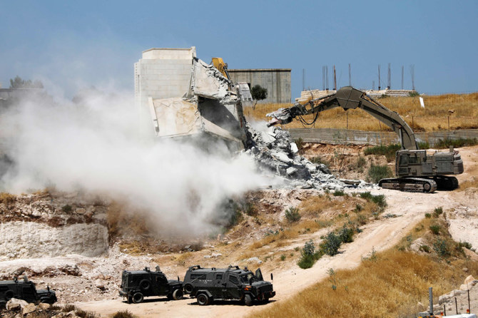 Israeli security forces tearing down one of the Palestinian buildings still under construction in the West Bank village of Dar Salah. (File/AFP)