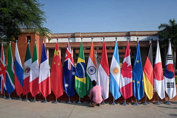 A man arranges the national flags of participating nations during the G20 foreign ministers’ meeting in New Delhi, India on March 2, 2023. (AFP)