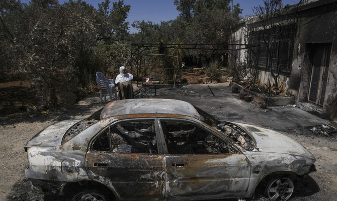 A Palestinian woman sits outside her torched home, days after it was set on fire by Jewish settlers, in the West Bank town of Turmus Ayya, on June 24, 2023. (AP)