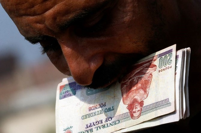 An Egyptian cattle trader counts money at Al-Manashi livestock market, ahead of the Muslim festival of Eid Al-Adha, Embama district, outskirts of Giza, Egypt, June 22, 2023. (Reuters)