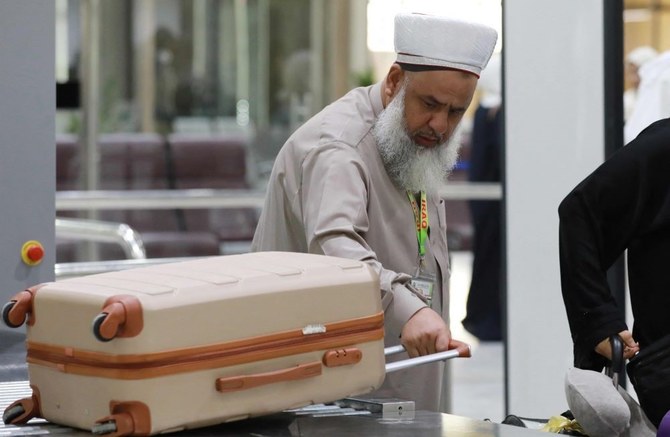 A Muslim pilgrim takes his luggage after inspection at the departure hall of Baghdad’s International airport on May 30, 2023, before leaving for the annual Hajj pilgrimage to Makkah. (AFP)