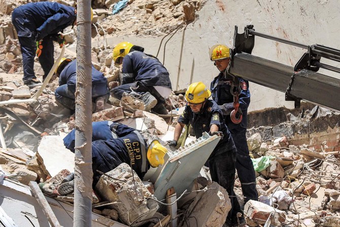 Civil defense first responders search through rubble at the scene of a collapsed 13-storey-building in the Sidi Bishr district of Alexandria on June 26, 2023. (AFP)