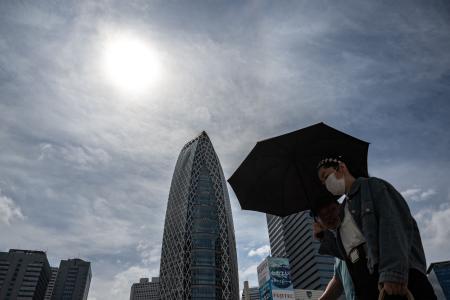 Pedestrians walk on a street in the Shinjuku district of Tokyo on June 1, 2023. (AFP)