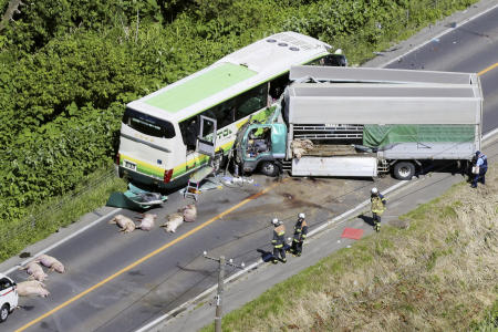 Investigators are seen at the scene of a crash between a bus and a truck in Yakumo, Hokkaido prefecture, northern Japan on June 18, 2023. (Kyodo News via AP)