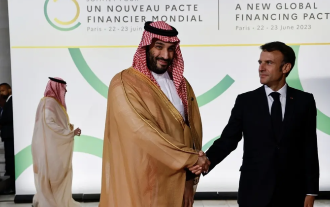 French President Emmanuel Macron (R) and Saudi Crown Prince Mohammed bin Salman pose for a photograph as they arrive at the Palais Brogniart for the New Global Financial Pact Summit in Paris on June 22, 2023. (AFP)