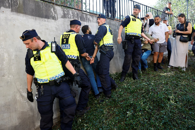 Police officers intervene after people's reaction as demonstrators burn the Koran (not pictured) outside Stockholm's central mosque in Stockholm, Sweden June 28. (Reuters)