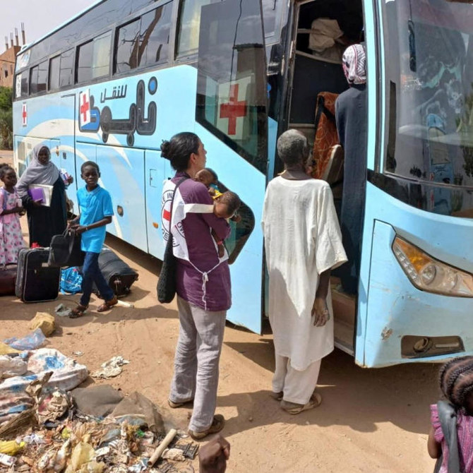 A worker from International Committee of the Red Cross carries children during the evacuation of children and caretakers from the Mygoma Orphanage in Khartoum in this handout image released on Jun. 7, 2023. (Reuters)