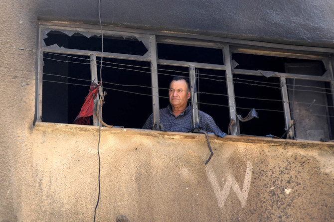 A man looks out from the shattered window of a building in the occupied West Bank's Jenin refugee camp on July 6, 2023, following a two-day Israeli military raid that ended with 12 Palestinians and one Israeli soldier killed. (AFP)