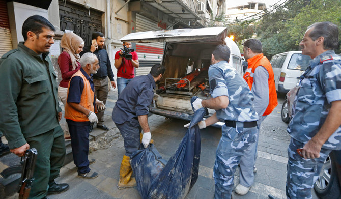 This file photo taken on October 11, 2017 shows Syrian security forces carry the remains of a reported suicide bomber following an attack near the main police headquarters in Syria's capital Damascus on October 11, 2017. (AFP)