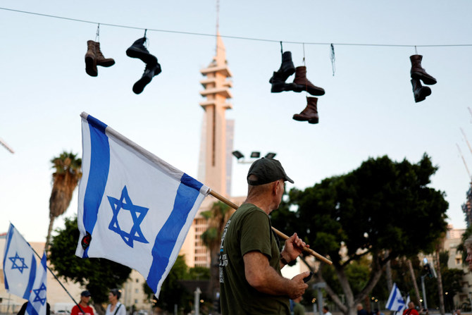 Army boots hang on a wire during a protest where military reservists sign pledge to suspend voluntary military service if the government passes judicial overhaul legislation near the defense ministry in Tel Aviv, Israel, on July 19, 2023. (REUTERS)