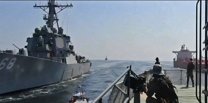 In this video grab of a footage broadcast by the Iranian state TV on Nov. 3, 2021, Iranian Revolutionary Guards navy units are shown observing a US warship (L) and a Vietnam-flagged oil tanker (R), in the Gulf of Oman. Iran has lost a bid to host a shipping event in Tehran in late October this year in conjunction with an annual maritime day hosted by the UN’s International Maritime Organization (IMO) because of its repeated seizure of commercial ships in the Arabian Gulf. (AFP file photo)
