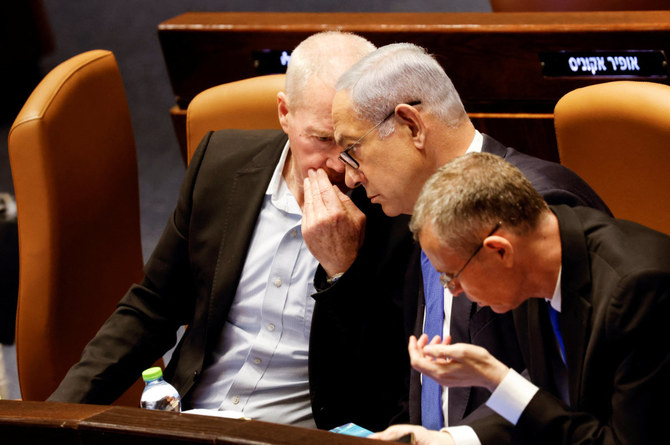 Israeli Defence Minister Yoav Gallant speaks with Prime Minister Benjamin Netanyahu as lawmakers gather at the Knesset plenum to vote on a bill that would limit some Supreme Court power, in Jerusalem July 24, 2023. (REUTERS)
